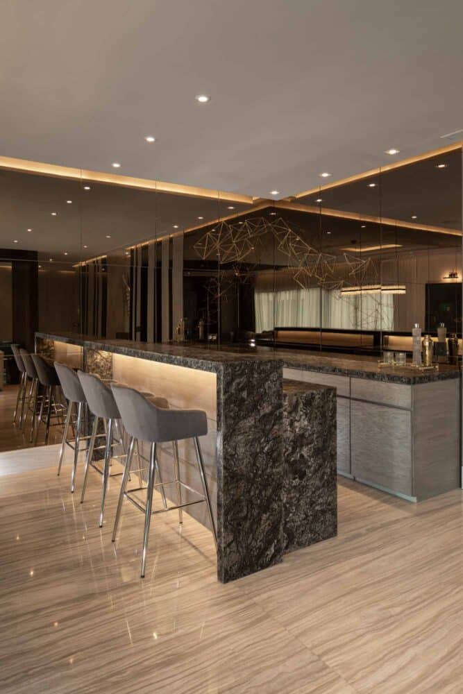 Esta imagen muestra una bar moderno y funcional, está decorado con un estilo contemporáneo y cuenta con una barra de mármol y sillas altas para bar.